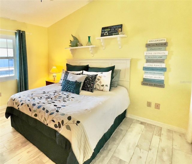 bedroom with lofted ceiling and wood-type flooring