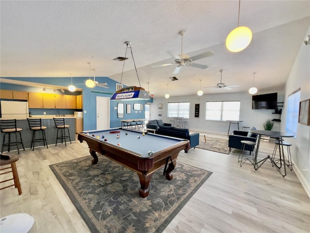 playroom with vaulted ceiling, pool table, a textured ceiling, and light hardwood / wood-style flooring