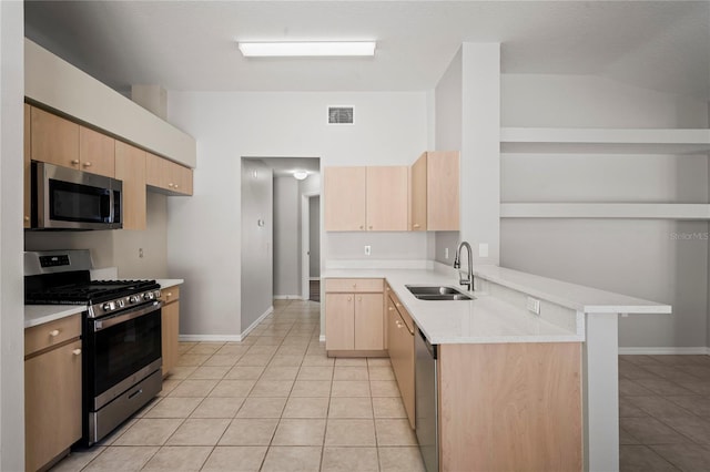 kitchen with light tile patterned flooring, appliances with stainless steel finishes, sink, and light brown cabinetry