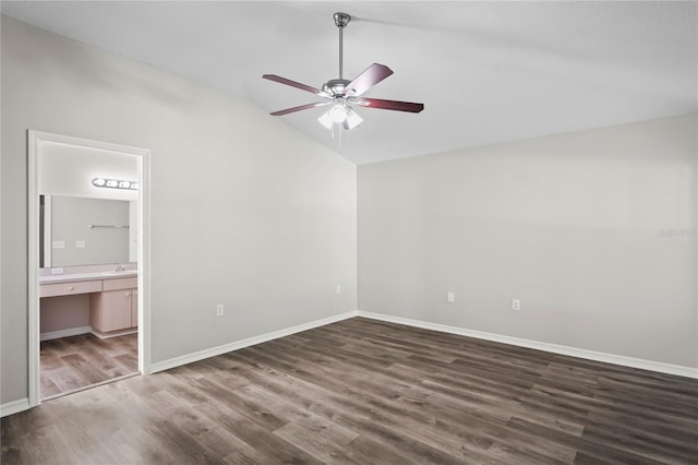 unfurnished bedroom featuring ceiling fan, connected bathroom, dark hardwood / wood-style flooring, and vaulted ceiling