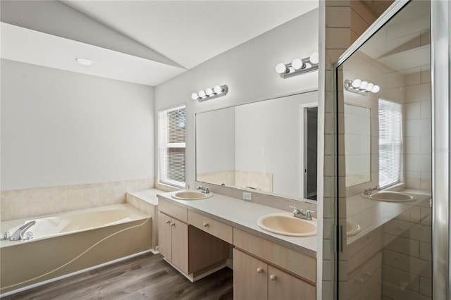 bathroom featuring hardwood / wood-style flooring, vanity, lofted ceiling, and plus walk in shower