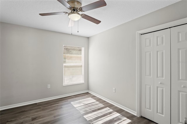 unfurnished bedroom with a closet, dark hardwood / wood-style floors, a textured ceiling, and ceiling fan