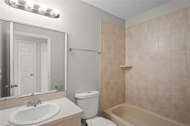 full bathroom featuring tiled shower / bath, vanity, toilet, and a textured ceiling