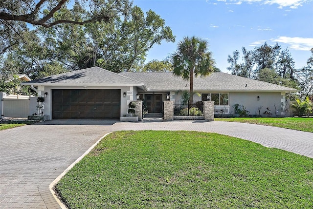 single story home featuring a garage and a front yard