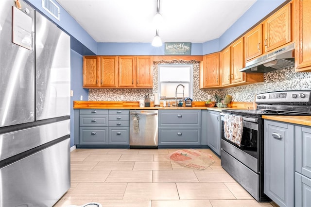 kitchen featuring visible vents, appliances with stainless steel finishes, gray cabinets, under cabinet range hood, and wooden counters