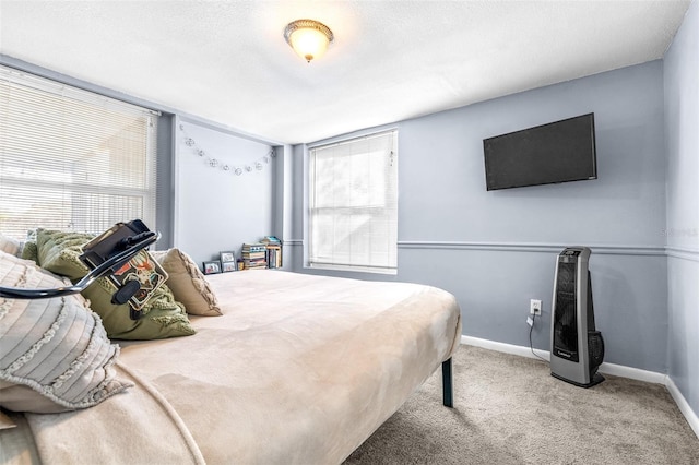 carpeted bedroom with a textured ceiling, multiple windows, and baseboards