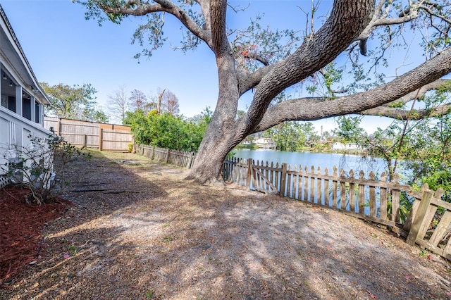 view of yard with a water view and a fenced backyard