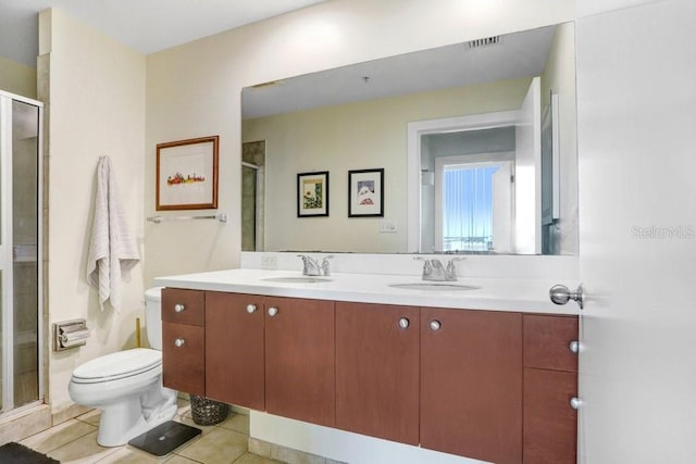 bathroom with vanity, a shower with shower door, tile patterned floors, and toilet