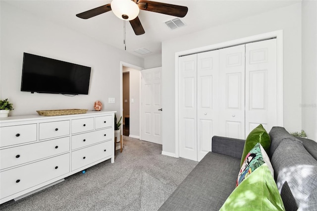 carpeted bedroom featuring ceiling fan and a closet