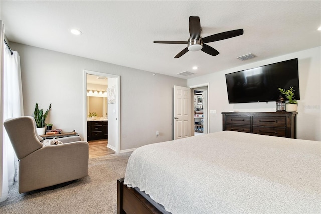 carpeted bedroom featuring ensuite bath and ceiling fan