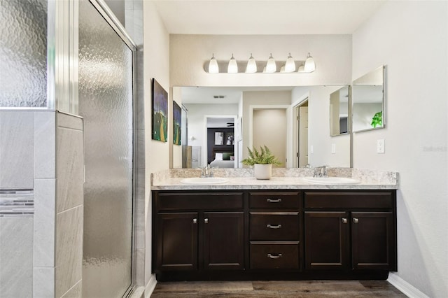 bathroom with walk in shower, vanity, and hardwood / wood-style floors