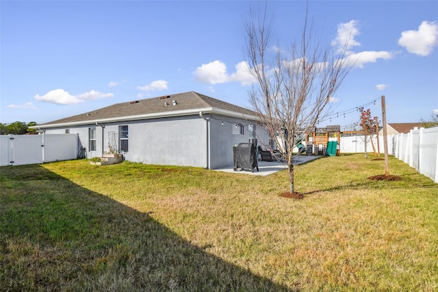 rear view of property with a yard and a playground