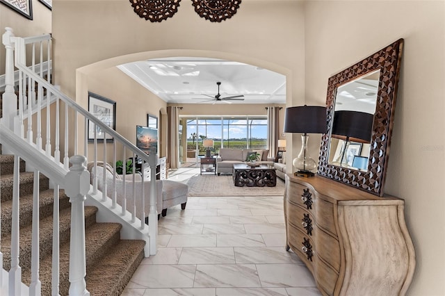 foyer with crown molding and ceiling fan