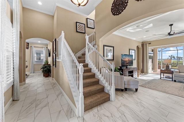 stairway featuring crown molding and ceiling fan