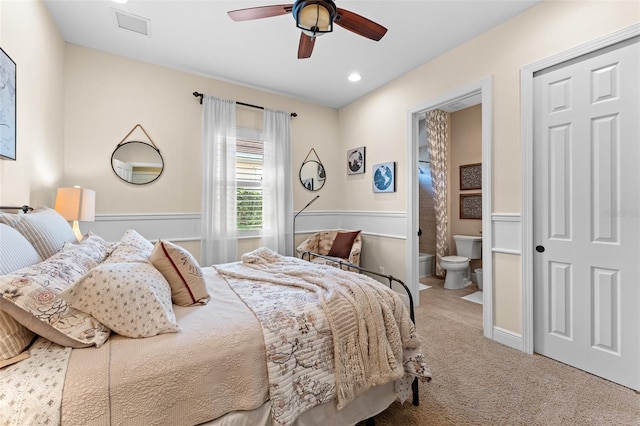 bedroom with ceiling fan, ensuite bathroom, and carpet