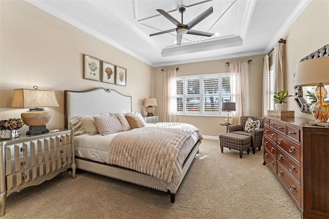 carpeted bedroom with ceiling fan, ornamental molding, and a raised ceiling