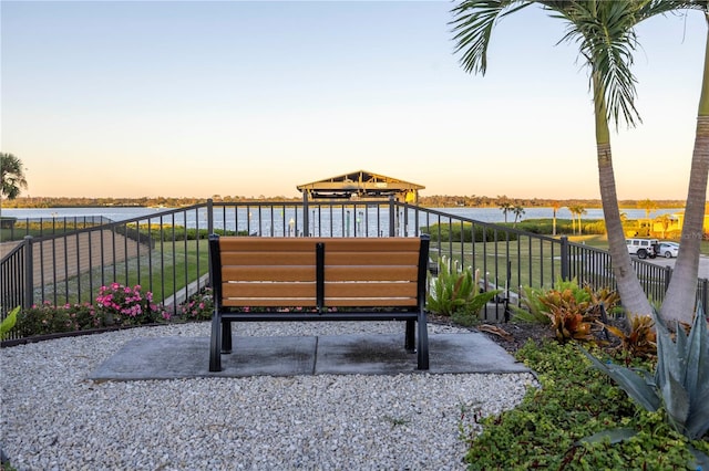 patio terrace at dusk featuring a water view