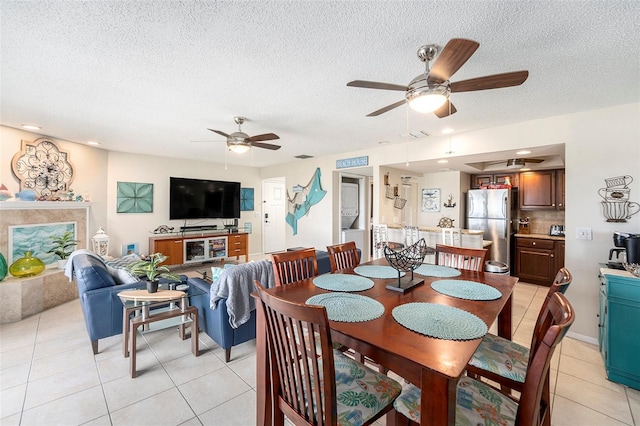 tiled dining area featuring ceiling fan and a textured ceiling