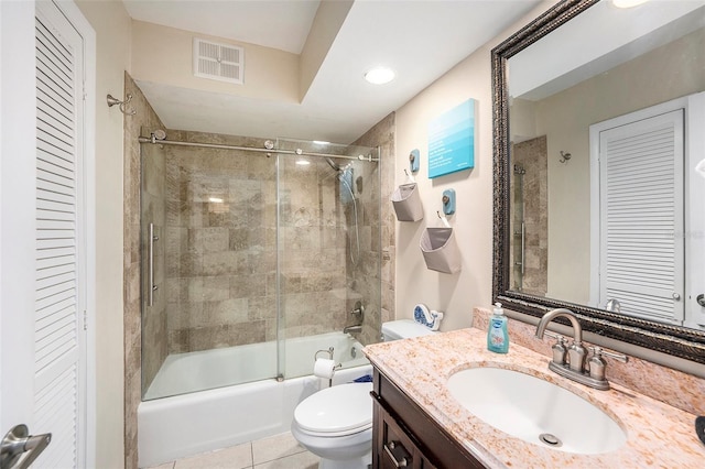 full bathroom featuring vanity, tile patterned floors, shower / bath combination with glass door, and toilet