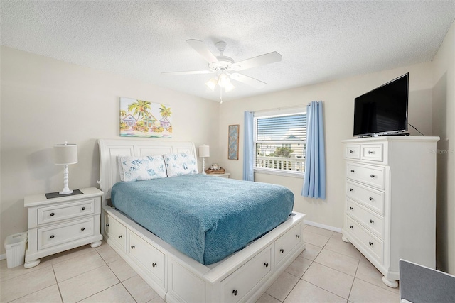 bedroom featuring ceiling fan, a textured ceiling, and light tile patterned flooring