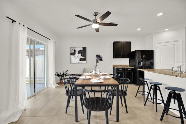 tiled dining area featuring ceiling fan and sink