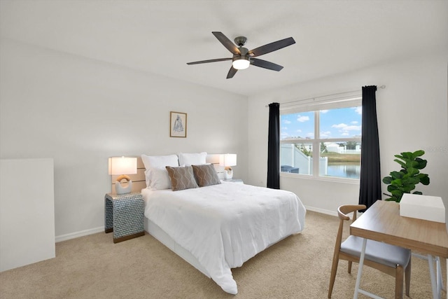 carpeted bedroom featuring ceiling fan and a water view