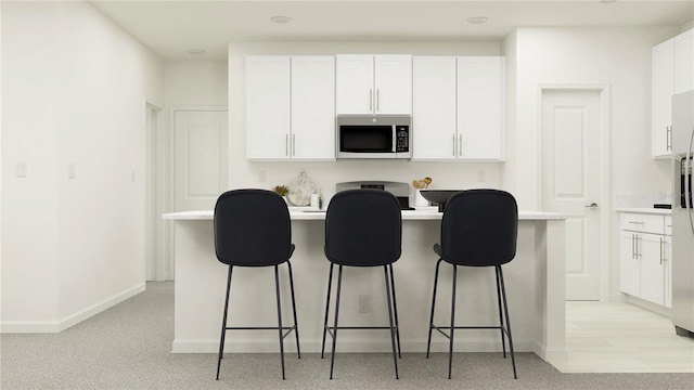 kitchen featuring white cabinetry and a kitchen breakfast bar