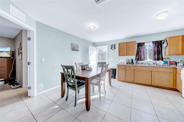 dining area featuring plenty of natural light, a textured ceiling, and light tile patterned flooring