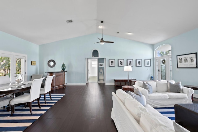 living room with high vaulted ceiling, a wealth of natural light, dark hardwood / wood-style flooring, and french doors