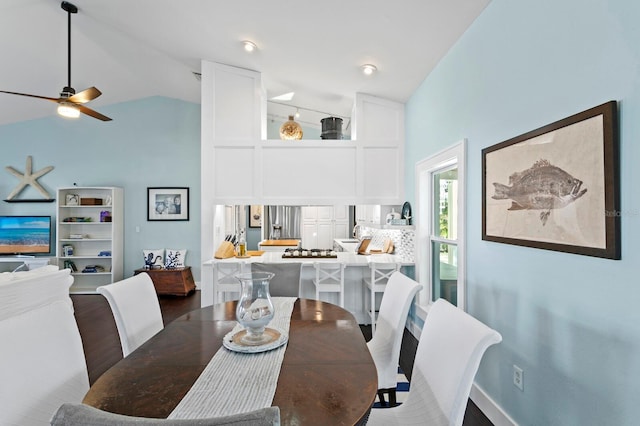 dining space with hardwood / wood-style flooring, high vaulted ceiling, and ceiling fan