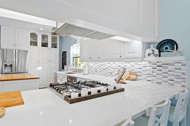 kitchen with sink, backsplash, stainless steel appliances, and white cabinets