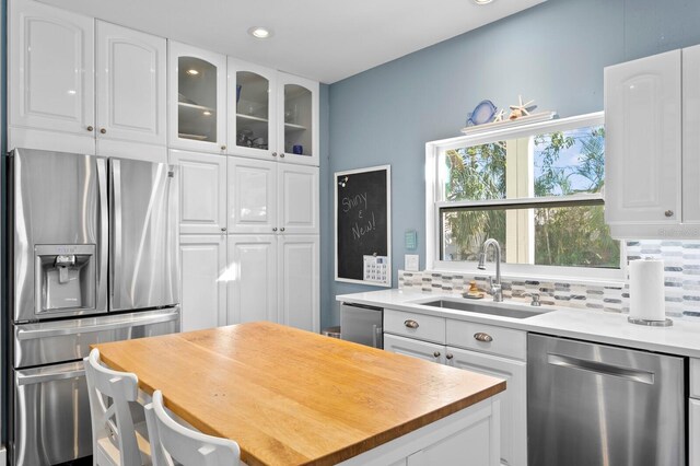 kitchen featuring white cabinetry, sink, tasteful backsplash, and appliances with stainless steel finishes