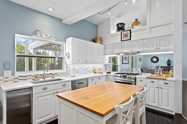 kitchen featuring white cabinetry, sink, decorative backsplash, a center island, and stainless steel appliances