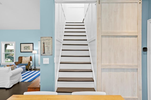 stairs featuring hardwood / wood-style flooring and a barn door