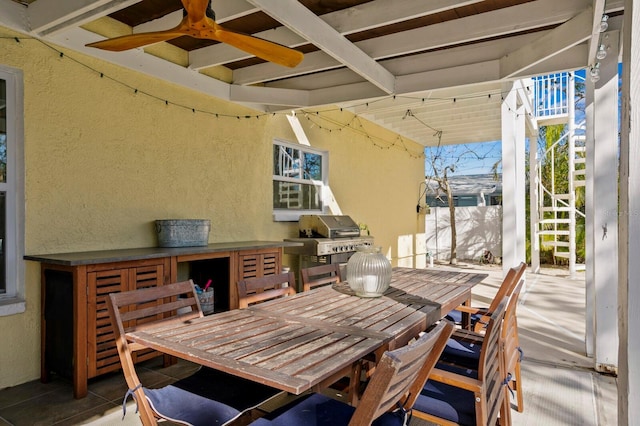 exterior space featuring grilling area, exterior bar, and ceiling fan