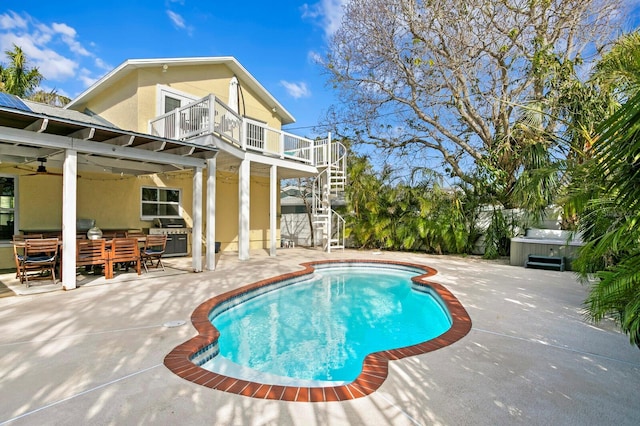 view of swimming pool with ceiling fan, a hot tub, and a patio area