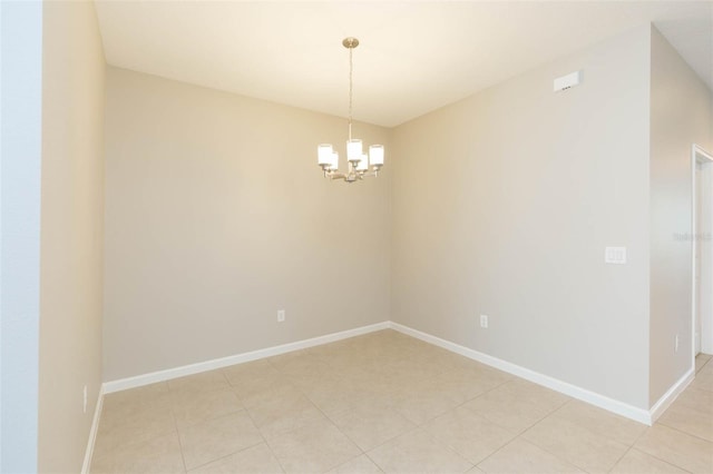 empty room with an inviting chandelier and baseboards