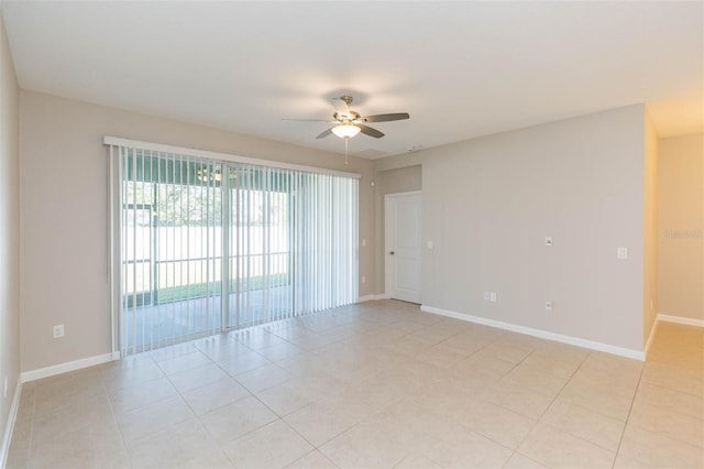 spare room featuring a ceiling fan, baseboards, and light tile patterned floors