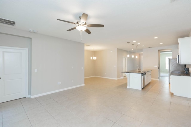 kitchen with visible vents, dark countertops, a kitchen island, hanging light fixtures, and white cabinetry