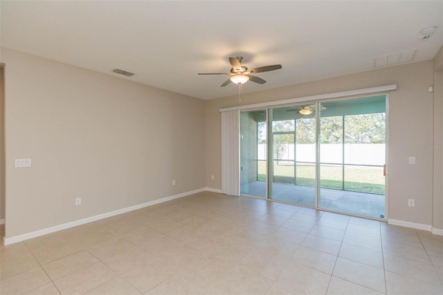 empty room with baseboards, light tile patterned floors, visible vents, and a ceiling fan