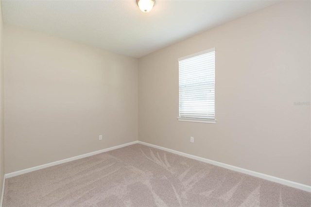 unfurnished room with carpet and baseboards