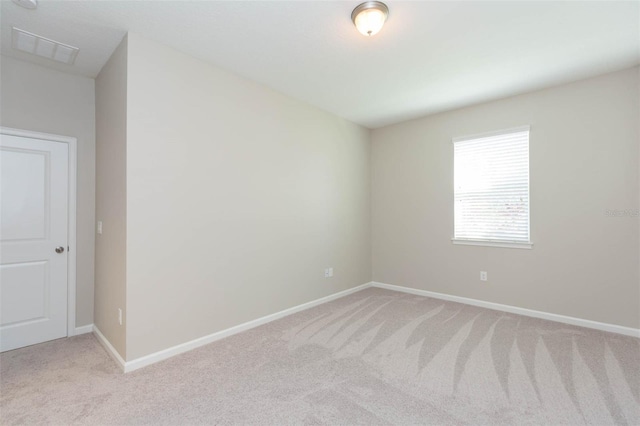 unfurnished room featuring light colored carpet, visible vents, and baseboards