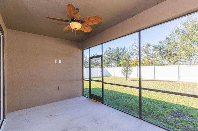 unfurnished sunroom featuring a ceiling fan