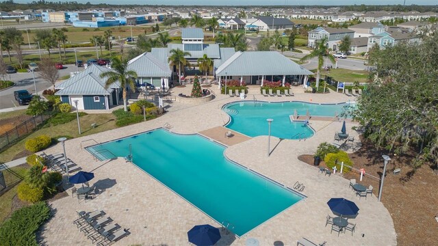 community pool with a residential view, fence, and a patio