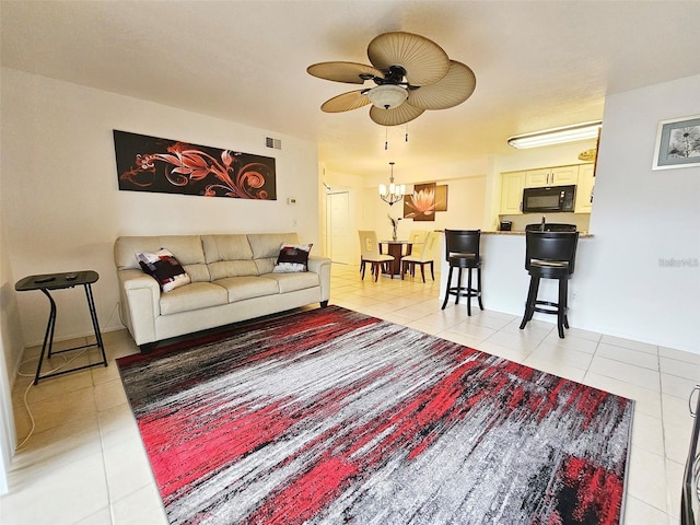 tiled living room featuring ceiling fan with notable chandelier