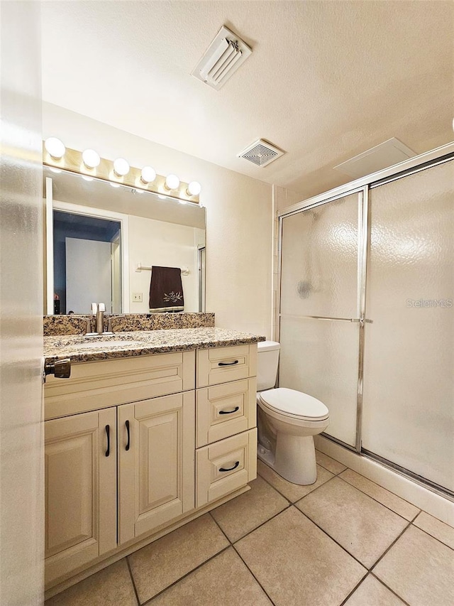 bathroom with walk in shower, tile patterned floors, vanity, and a textured ceiling