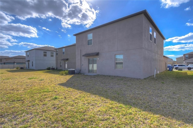 back of house with cooling unit and a lawn