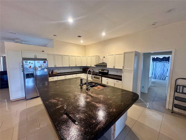 kitchen with appliances with stainless steel finishes, sink, and an island with sink