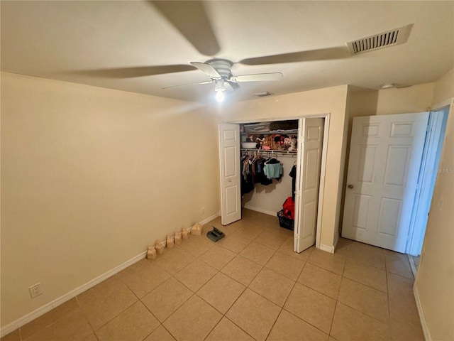 unfurnished bedroom featuring light tile patterned flooring, ceiling fan, and a closet