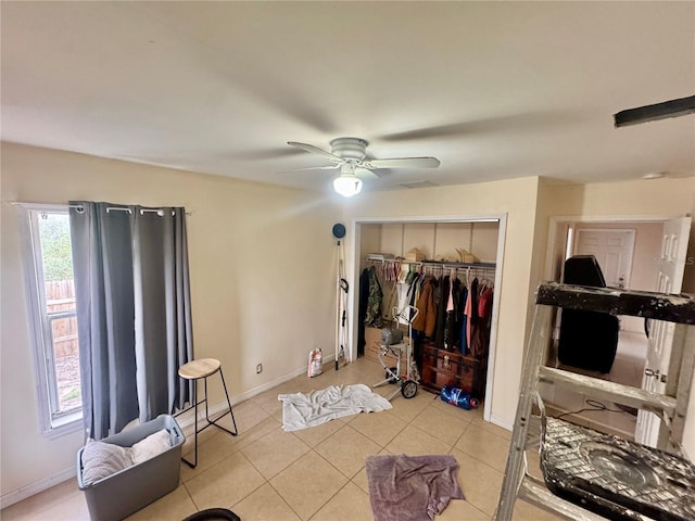 bedroom with light tile patterned flooring, ceiling fan, and a closet